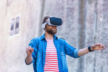 Man walking in the street in augmented reality headset. Virtual reality and futuristic technology concept.の写真素材