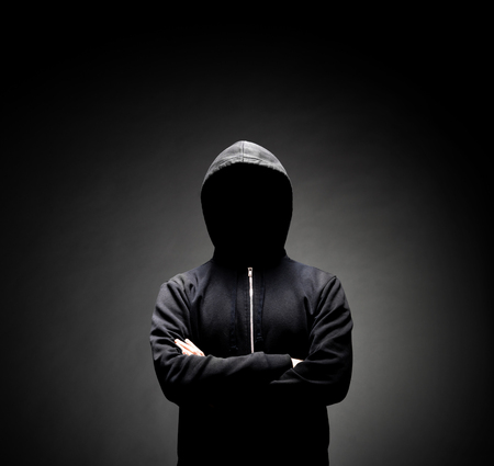 Computer hacker in hoodie. Obscured dark face. Data thief, internet fraud, darknet and cyber security concept.の写真素材