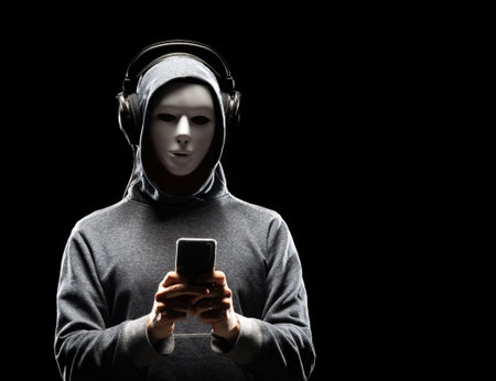 Computer hacker in white mask and hoodie. Obscured dark face. Data thief, internet fraud, darknet...