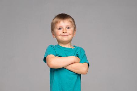 Portrait of happy smiling boy in blue t-shirt. Attractive kid in studio.の写真素材