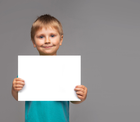 Portrait of happy smiling boy in blue t-shirt. Attractive kid in studio.の写真素材