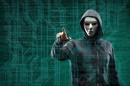 Dangerous hacker over abstract digital background with binary code. Obscured dark face in mask and hood. Data thief, internet attack, darknet fraud, virtual reality and cyber security.の写真素材