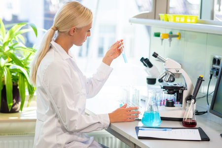 Female scientist working in modern lab. Doctor making microbiology research. Laboratory tools:...