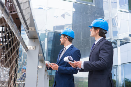 Real estate developers in helmets. New office construction. Confident business men and architect...