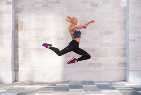 Attractive woman in sportswear training outdoor. Sport, jogging, healthy and active lifestyle.の写真素材