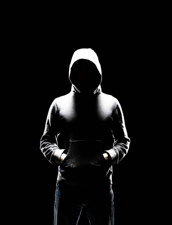 Computer hacker in hoodie. Obscured dark face. Data thief, internet fraud, darknet and cyber security concept.の写真素材