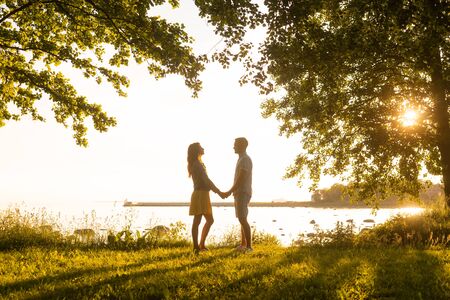 Loving man having date with his beautiful girlfriend. Field and sea background.の写真素材
