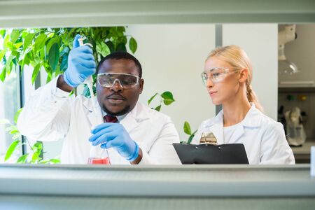 Scientist and students working in lab. Doctor teaching interns to make blood analyzing research. Coronavirus, chemistry, bacteriology, virology and health careの写真素材