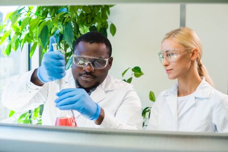 Scientist and students working in lab. Doctor teaching interns to make blood analyzing research. Coronavirus, chemistry, bacteriology, virology and health careの写真素材