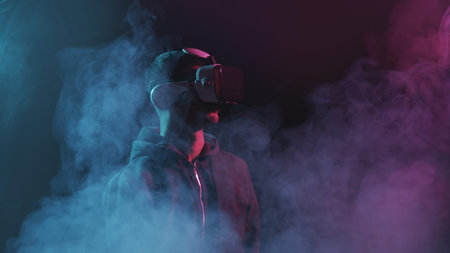 Portrait of a man in virtual reality helmet. Obscured dark face in VR goggles. Internet, darknet,...