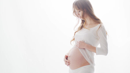 Happy pregnant woman touching her beautiful belly. Pregnancy, motherhood, and expectation