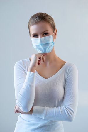 Portrait of young and natural woman in medcial mask. Pandemic, coronavirus, covid-19 and protection concept.の写真素材