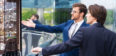 Teamwork and business concept. Confident businesspersons having conversation about banking and financial markets in front of office building.の写真素材