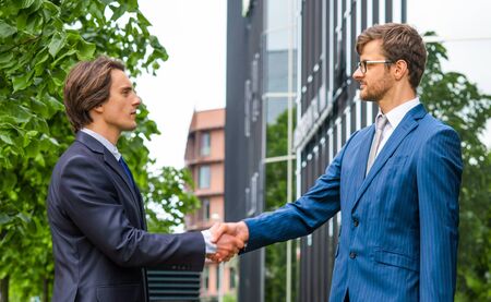 Confident businesspersons in formal wear having conversation about banking and financial markets in front of office building.の写真素材