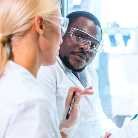 Scientist and students working in lab. Doctor teaching interns to make blood analyzing research. Coronavirus, chemistry, bacteriology, virology and health careの写真素材