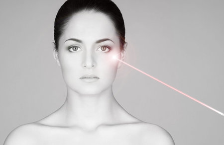 Removing birthmarks with a laser ray. Beautiful face of a young woman.の写真素材