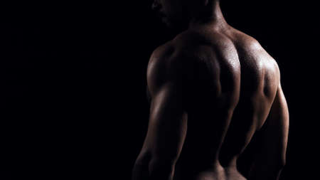 Fit and sporty bodybuilder over black background. Sportsman in studio. Sport and fitness concepts.の写真素材
