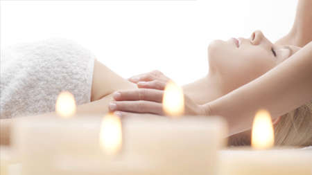 Young, beautiful and healthy woman in massaging salon. Traditional face massage therapy and skin care.の写真素材