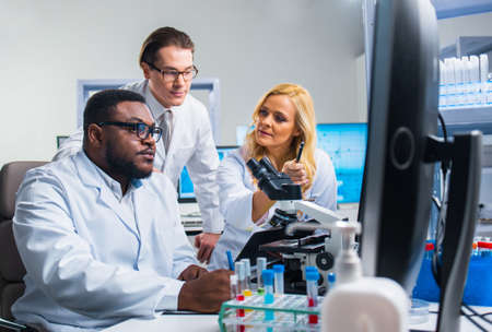 Professional team of scientists is working on a vaccine in a modern scientific research laboratory. Genetic engineer workplace. Future technology and science.の写真素材