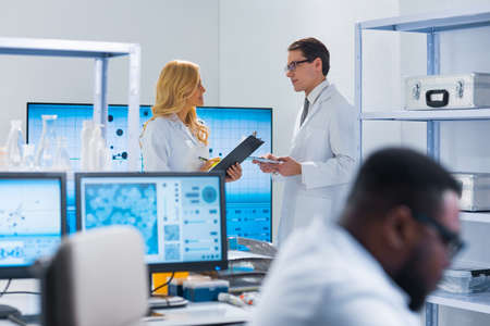 Professional team of scientists is working on a vaccine in a modern scientific research laboratory. Genetic engineer workplace. Future technology and science.の写真素材