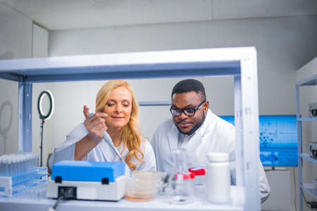 Professional team of scientists is working on a vaccine in a modern scientific research laboratory. Genetic engineer workplace. Future technology and science.の写真素材