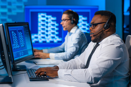 Call-center worker is speaking with the client by headset. Workplace of the african-american support operator.の写真素材