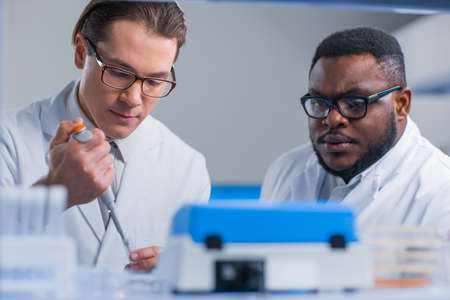 Professional team of scientists is working on a vaccine in a modern scientific research laboratory. Genetic engineer workplace. Future technology and science.の写真素材