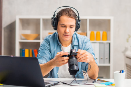 Freelance photographer workplace at home office. Young man works using computer, graphic tablet,...