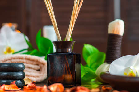 Spa background. Towel, candles, flowers, aroma sticks, massaging stones and herbal balls. Massage, oriental therapy, wellbeing and meditation.の写真素材