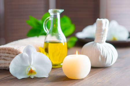 Spa background. Towel, candles, orchid flowers and herbal balls. Massage, oriental therapy, wellbeing and meditation.の写真素材