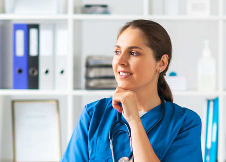 Professional medical doctor working in hospital office, Portrait of young and attractive female physician in protective mask.の写真素材