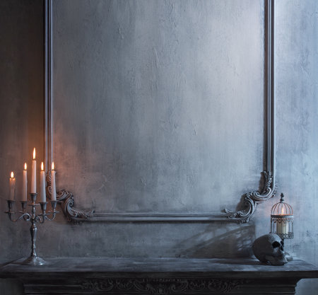 Mystical Halloween still-life background. Skull, candlestick with candles, old fireplace. Horror and witchery.の写真素材
