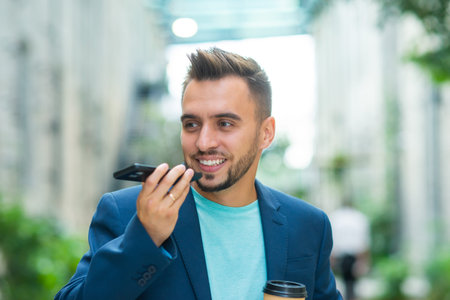 A young successful businessman is working outdoor using smartphone. Man in a casual wear. Business,...