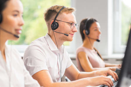 Diverse team of young professionals is working in the phone support office. Working day of sales managers in the call center. Business, telephone consulting and problem solving.の写真素材