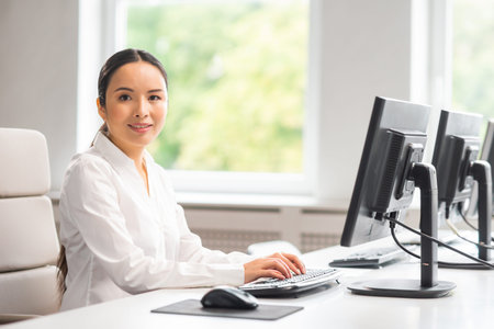 Asian business woman is working at her table in a modern office. The workplace of a successful...