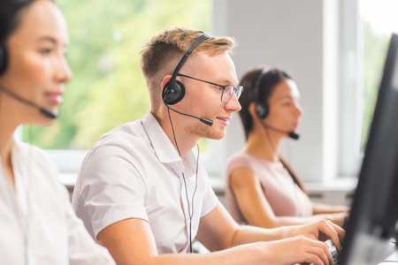 Diverse team of young professionals is working in the phone support office. Working day of sales managers in the call center. Business, telephone consulting and problem solving.の写真素材