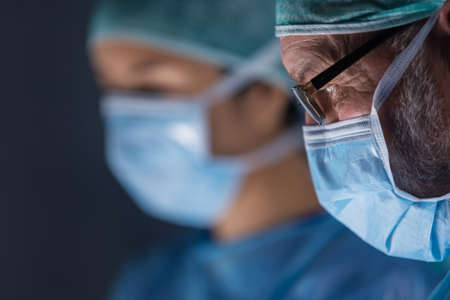 Multiracial team of professional medical surgeons performs the surgical operation in a modern hospital. Doctors are working to save the patient. Medicine, health, cardiology and transplantation.の写真素材