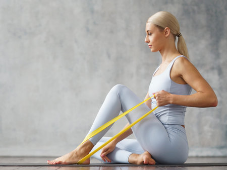 Young slender blonde woman in sportswear is engaged in fitness at home. Sport, health and lifestyle...