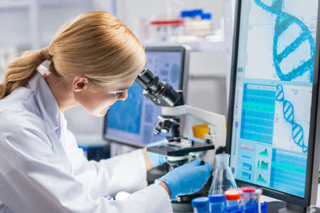 Professional female scientist is working on a vaccine in a modern scientific research laboratory. Genetic engineer workplace. Future technology and science.の写真素材