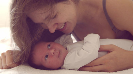 Newborn baby boy and his mother at home. Close-up portrait of the infant who has recently been born....