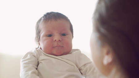 Newborn baby boy and his mother at home. Close-up portrait of the infant who has recently been born....