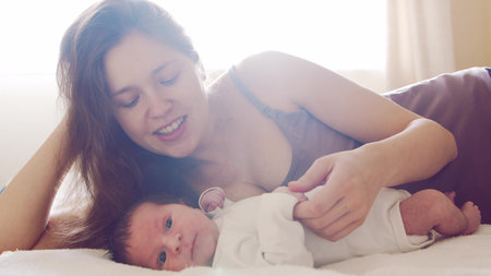 Newborn baby boy and his mother at home. Close-up portrait of the infant who has recently been born....