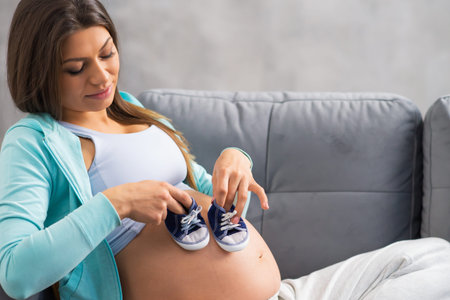 Young pregnant woman is resting at home and expecting a baby. Pregnancy, motherhood, health care and...