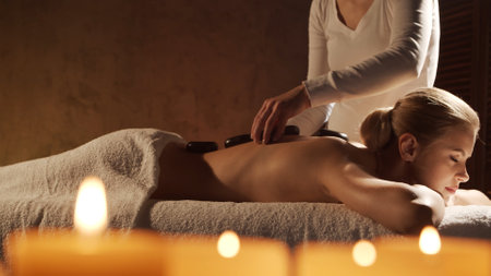 Young, healthy and beautiful woman gets massage therapy in the spa salon. Healthy lifestyle and body care concept.の写真素材