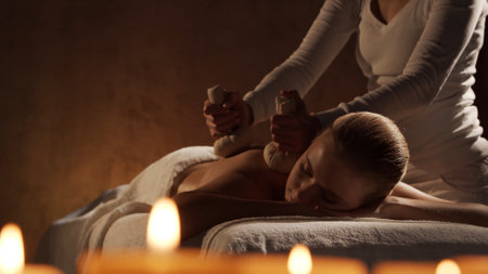 Young, healthy and beautiful woman gets massage therapy in the spa salon. Healthy lifestyle and body care concept.の写真素材