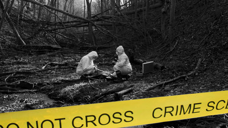 Detectives are collecting evidence in a crime scene. Forensic specialists are making expertise. Police investigation in a forest. Black and white image with yellow police line.