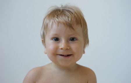 Little, happy and smiling cute baby in the studio. Portrait of a one year old baby. The concept of happiness.の写真素材