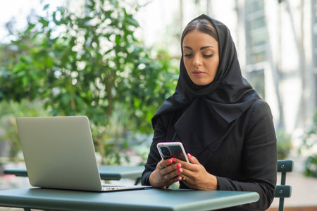 Close-up portrait of young and attractive muslim woman in hijab. Middle Eastern woman outdoor on the street. City background. Business concept.の写真素材