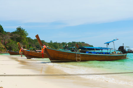 Thai traditional wooden longtail boat and beautiful sand beach in Thailand. Traveling concept.