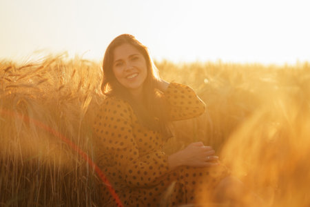 Close-up portrait of beautiful young woman in a countryside field. Female face in the rays of sunset. Freedome and happiness concept.の写真素材